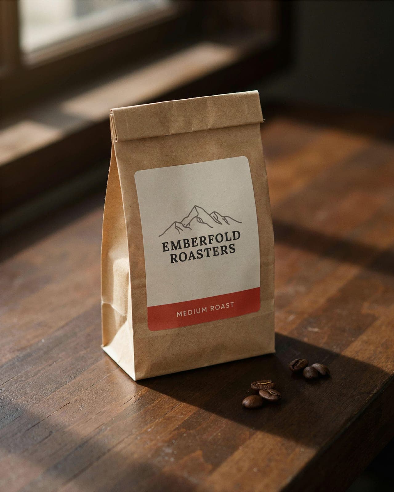A kraft coffee bag labelled Emberfold Roasters, Medium Roast, on a walnut counter generated with BrandGen