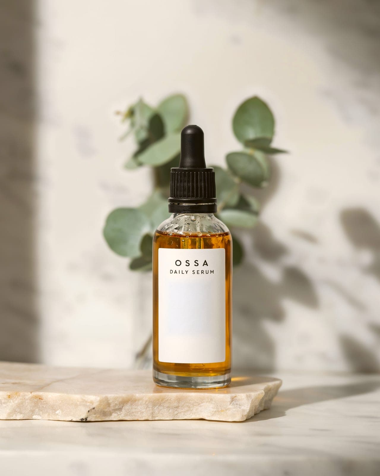 The amber bottle on a white marble shelf with a eucalyptus sprig behind it generated with BrandGen